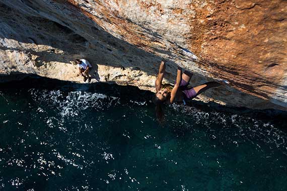 Climb above water in Majorca. Deep water solo. Vertical sailing tour